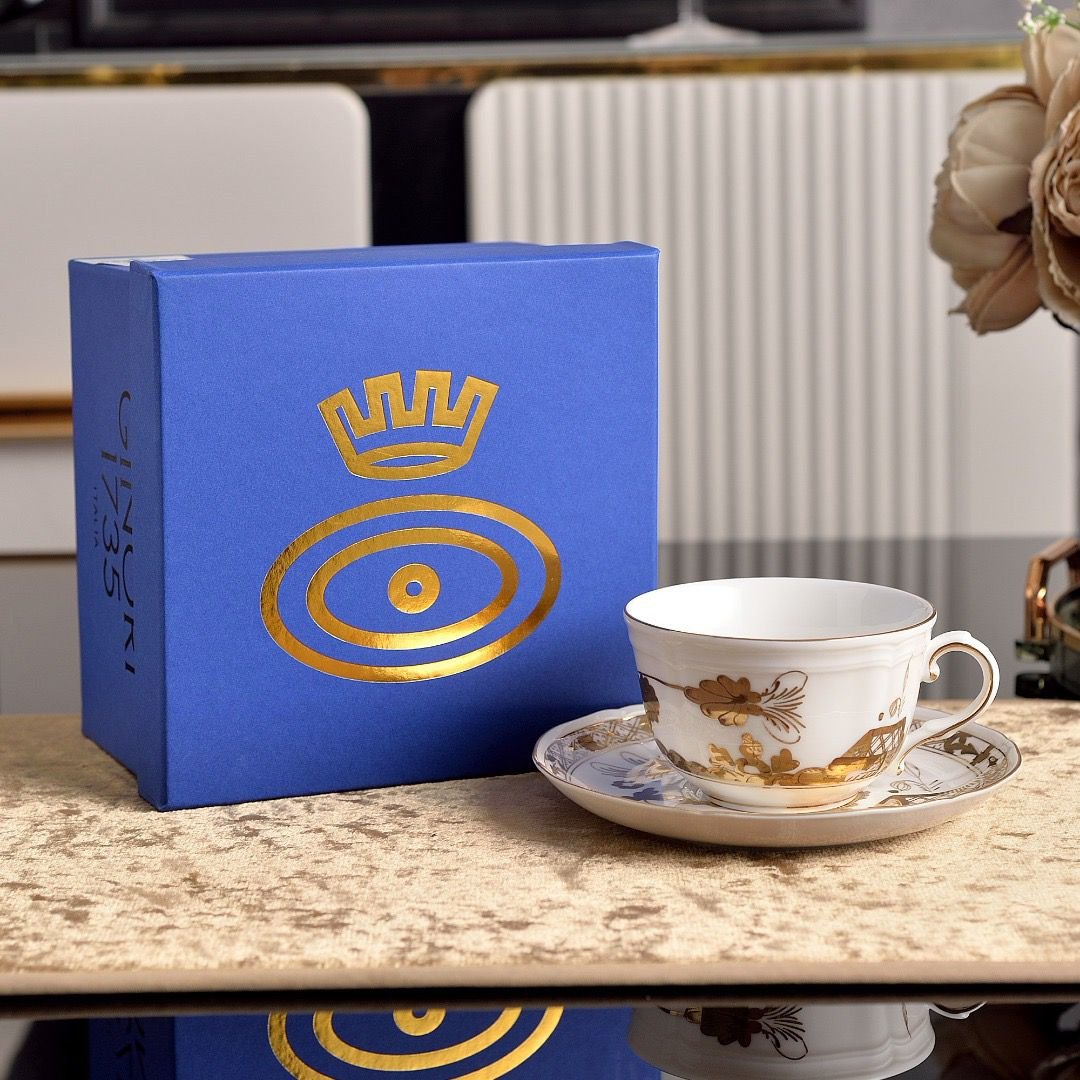 A coffee cup and saucer from Ginori 1735 Oriente Italiano Aurum, made of white porcelain and decorated with floral motifs painted in gold. - Ginori Cups | Aleppo Gift UAE